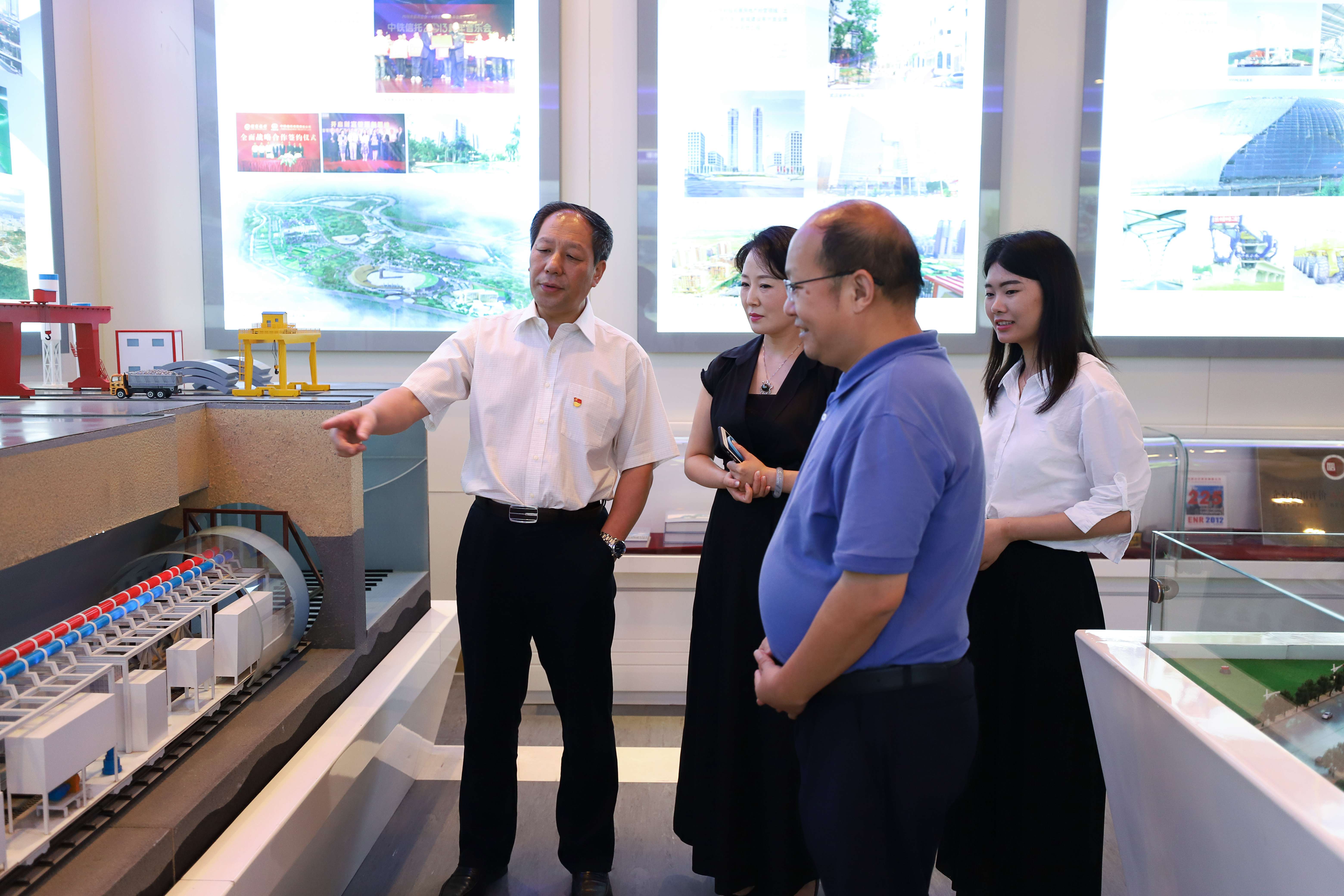 中國中鐵董秘何文（左一）向《證券日報(bào)》記者介紹中鐵盾構(gòu)模型。（圖片來源：證券日報(bào)）.jpg